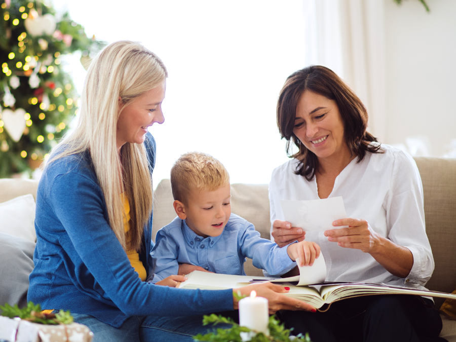 Mother, daughter, and grandson looking at old photographs.